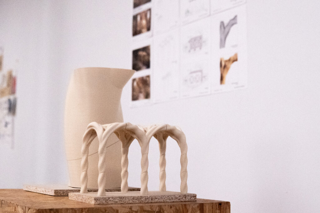 3D-printed vault model with twisted columns in front of presentation boards