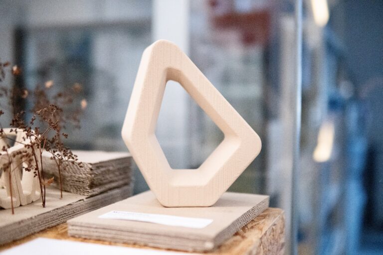 Wooden ring sculpture model on a plinth